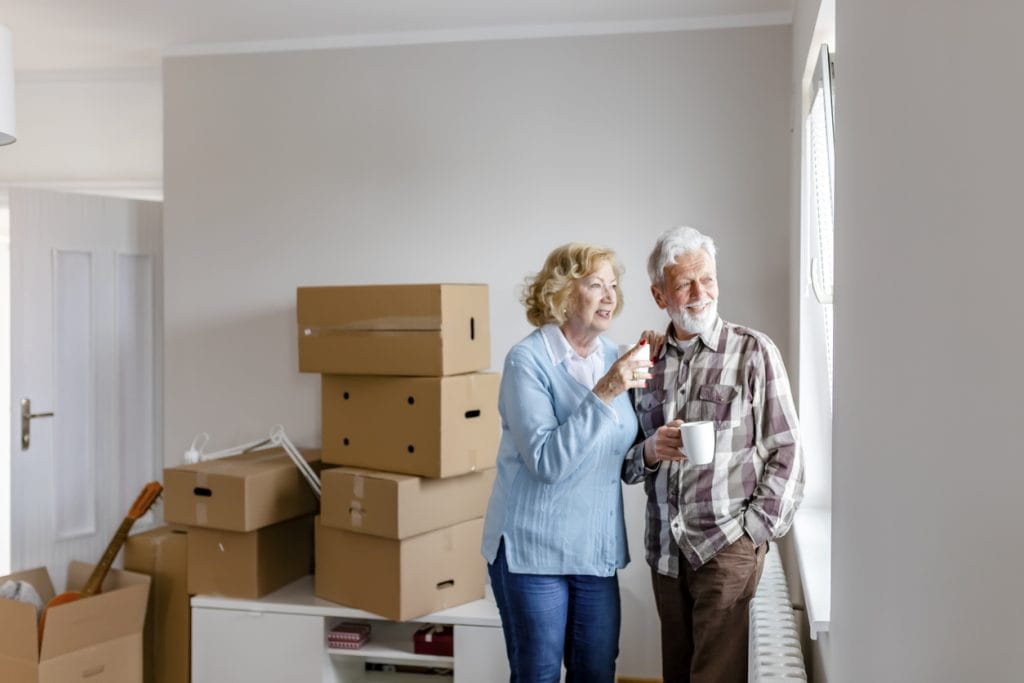 Couple packing their belongings into boxes to move home.