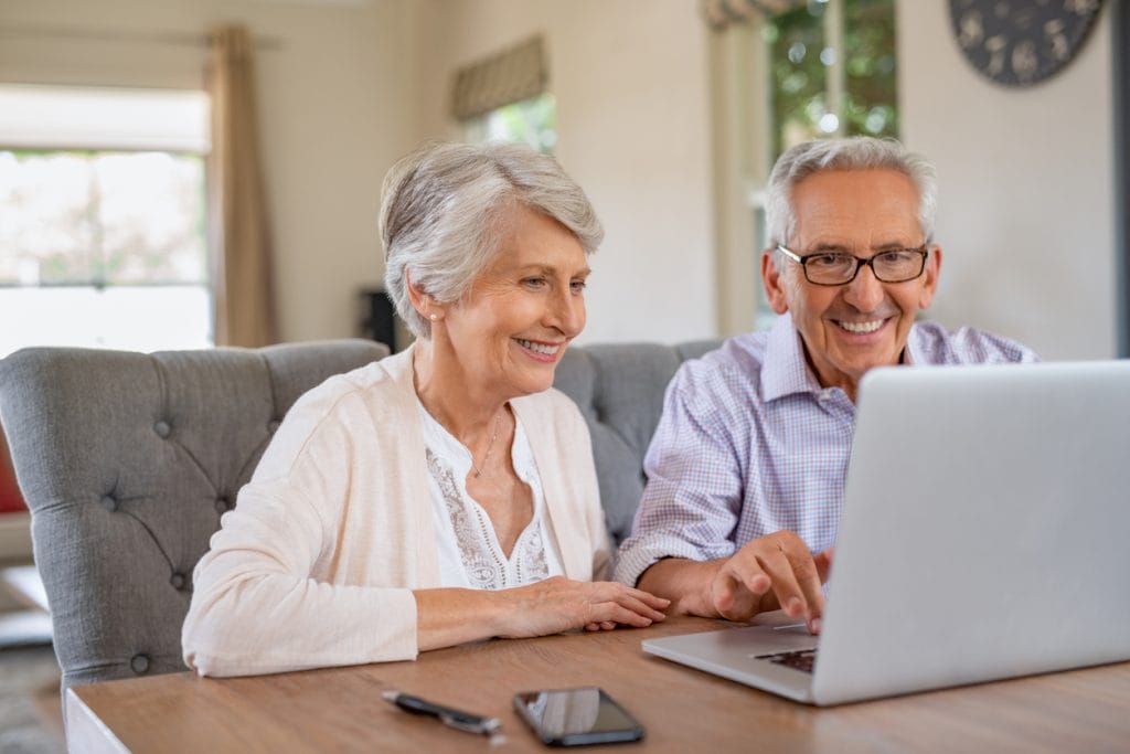 Senior couple reviewing equity release options on a laptop