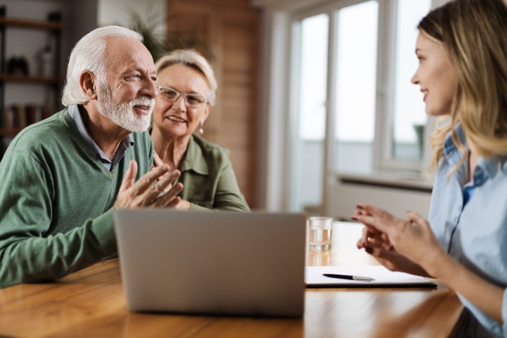 Couple having a discussion with an equity release adviser in their home