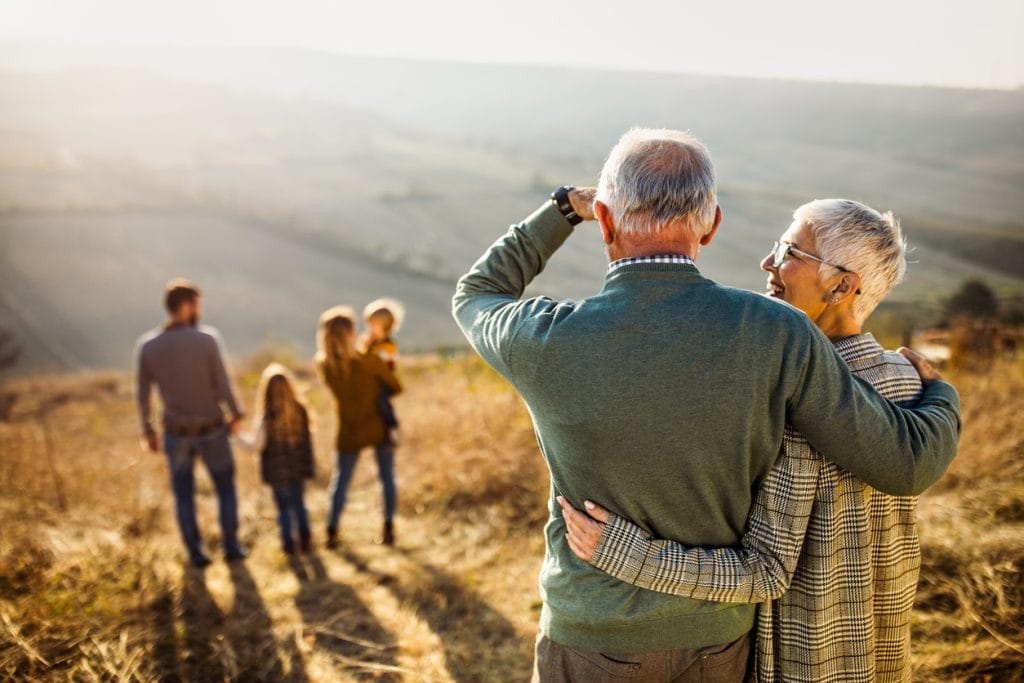 Grandparents watching children play knowing they are prepared with a will and power of attorney